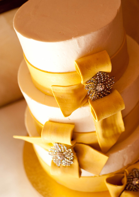 art_wedding_photographer034 gold and white wedding cake with broach on it